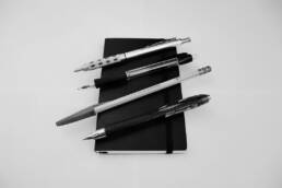 Pocket Notebook with pens and pencils ontop