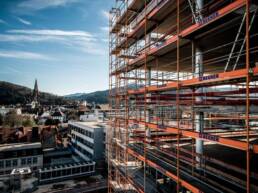 red scaffolding on a city scape with sky