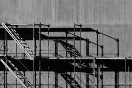 black and white photo of scaffolding by a building wall